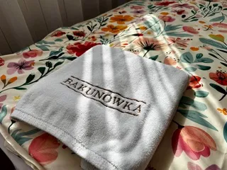 Ręcznik z logo Bakunówka na łóżku