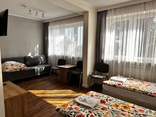 Pokój wieloosobowy z łóżkami, sofą i telewizorem